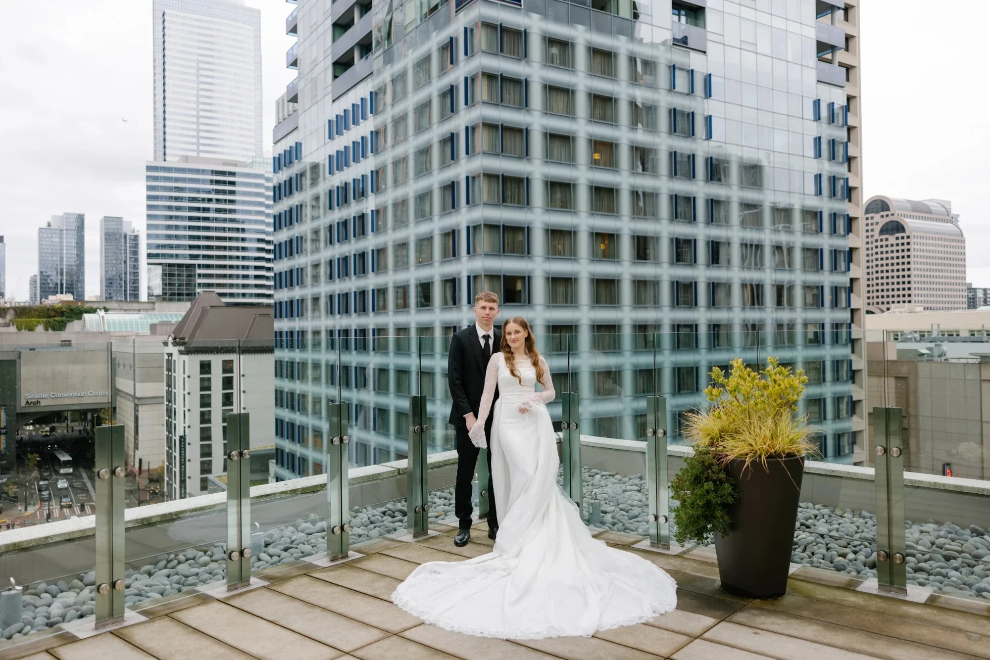 Bride and groom on a downtown Seattle rooftop terrace among glass towers