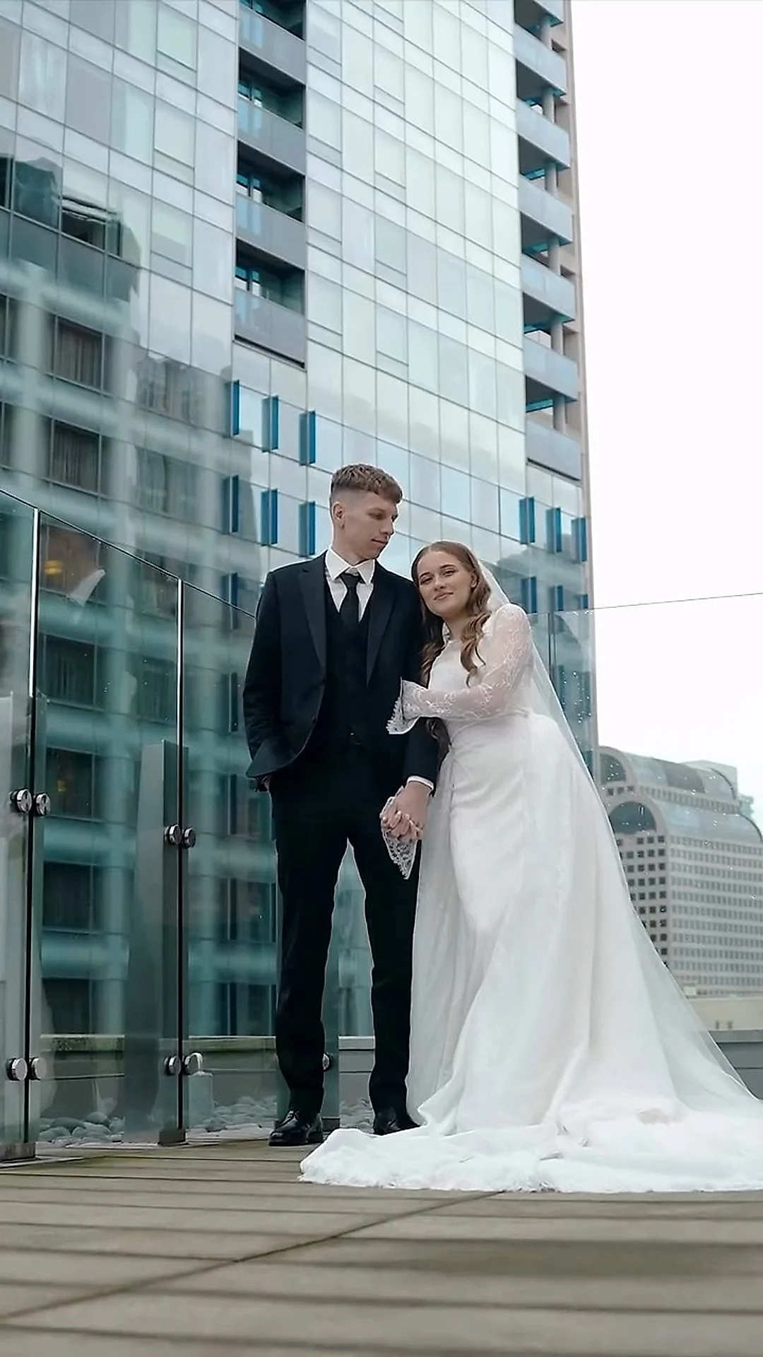 Couple on a rooftop terrace with a city tower behind them